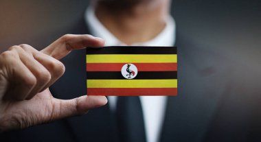 Uganda bayrağı kartı tutan işadamı