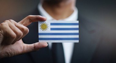 Uruguay bayrağı kartı tutan işadamı