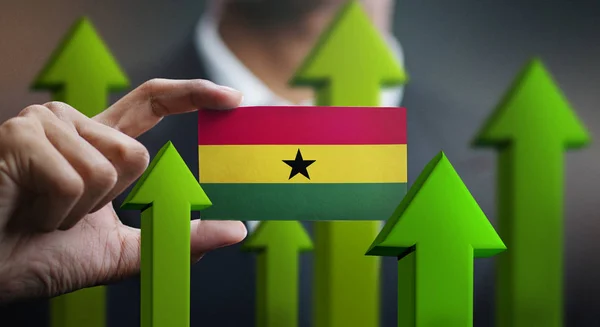 Nation Growth Concept, Green Up Arrows - Businessman Holding Card of Ghana Flag