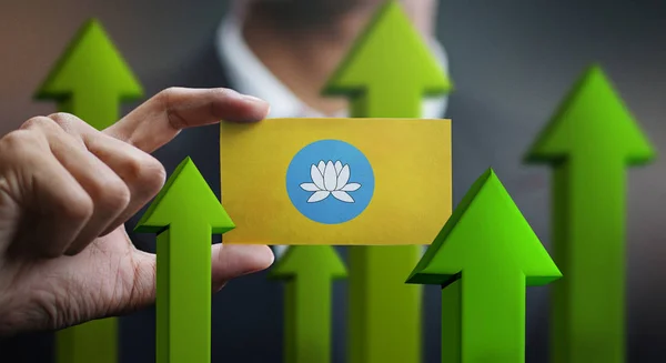 Nation Growth Concept, Green Up Arrows - Businessman Holding Card of Kalmykia Flag