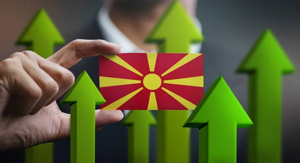 Nation Growth Concept, Green Up Arrows - Businessman Holding Card of Republic of Macedonia Flag