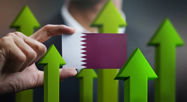 Nation Growth Concept, Green Up Arrows - Businessman Holding Card Qatar Flag