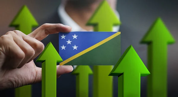 Nation Growth Concept, Green Up Arrows - Businessman Holding Card of Solomon Islands