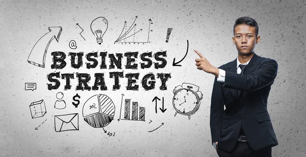 Азіатський бізнесмен вказуючи "бізнес-стратегія" текст ескіз Conce — стокове фото