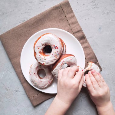 Gri arka plandaki kahverengi peçetedeki beyaz tabakta bebek eli çörekler.