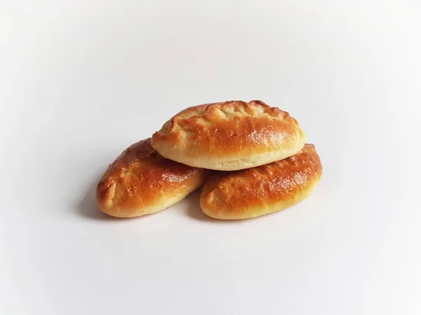 Geleneksel Rus usulü pirozhki turtaları. Beyaz arka plan. İzole. Turtalar lahana, elma, yumurta, böğürtlen, meyve ve etle pişirilebilir. Altın hamurlu mayalı çörekler.