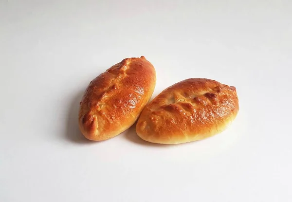 Geleneksel Rus usulü pirozhki turtaları. Beyaz arka plan. İzole. Turtalar lahana, elma, yumurta, böğürtlen, meyve ve etle pişirilebilir. Ev yapımı.