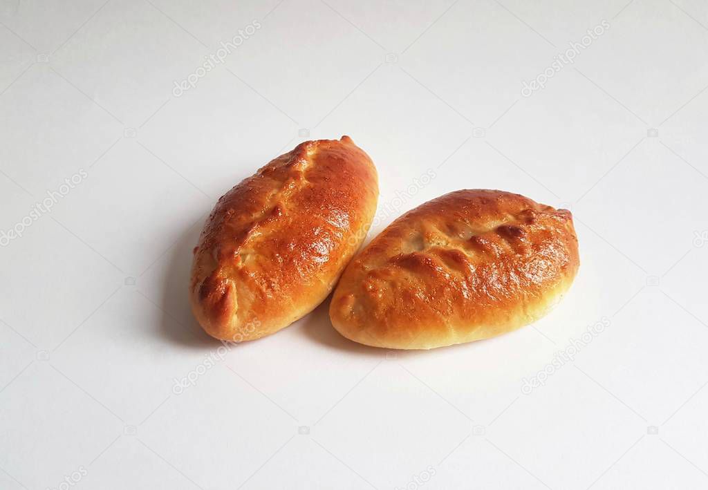 Traditional Russian baked pies pirozhki (patties). White background. isolated. Pies can be cooked with cabbage, apples, eggs, berries, fruit, meat. Homemade
