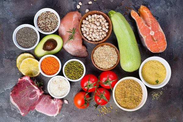 Organic Healthy food Clean eating selection Including Certain Protein Prevents Cancer: fish, meat, spice, vegetable, cereal on a dark stone backgound flat lay. Healthy and diet concept