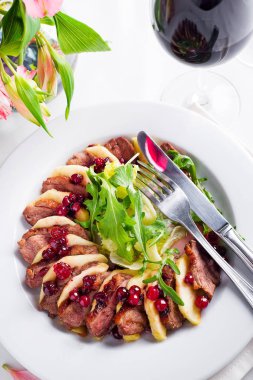 Ördek göğsü ile elma ve salata şarap ve beyaz masaya çiçek yabanmersini sosu altında dilimleri ile servis. Popüler Asya gıda