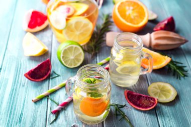 Taze narenciye limonata limes ve mason kavanoz mavi bir arka plan üzerinde limon ile.