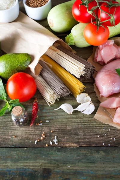 イタリアのスパゲティ 生そば Comen 鶏の生肉 アボカド 古い木製の背景にトマトとズッキーニ フレイ コピー スペースとレイアウト 自家製の料理のコンセプト — ストック写真