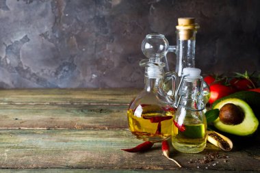Bitkisel yağ ile keten, biber ve ahşap arka plan, kopya alanı üzerinde avokado çeşitleri ile şişe
