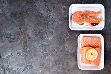 iki taze çiğ somon biftek polistren köpük taş zemin üzerine yapılan beyaz gıda tepsi üzerinde döşeme. Yağsız protein. Düz kopya alanı ile yatıyordu