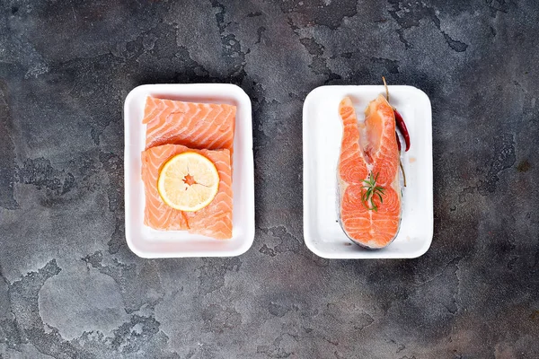 iki taze çiğ somon biftek polistren köpük taş zemin üzerine yapılan beyaz gıda tepsi üzerinde döşeme. Yağsız protein.
