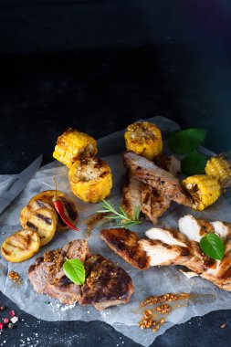 Üç çeşit kağıt üzerinde karanlık bir arka plan üzerine kıyılmış tavuk eti, domuz eti ve Mısır ile sığır eti, baharat