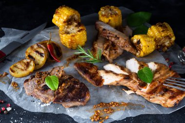 Üç çeşit kağıt üzerinde karanlık bir arka plan üzerine kıyılmış tavuk eti, domuz eti ve Mısır ile sığır eti, baharat