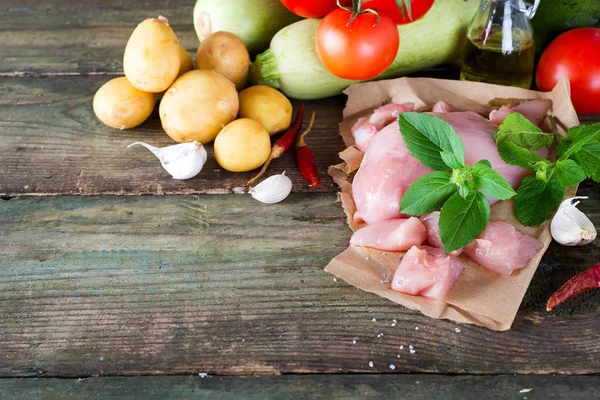 Seçim tavuk domates, kabak ve patates ahşap tahta, çiğ et. Üstten görünüm.