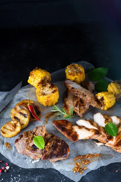 Üç çeşit kağıt üzerinde karanlık bir arka plan üzerine kıyılmış tavuk eti, domuz eti ve Mısır ile sığır eti, baharat