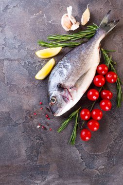 Limon dilimleri, baharatlar, otlar ve sebze taş zemin üzerine taze çiğ kılıçbalığı veya çipura balık. Akdeniz mutfağı. Üstten görünüm