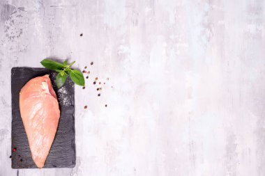 Taş zemin üzerine taze fesleğen çiğ tavuk göğsü kayrak tabakta. Pişirme madde, sağlıklı yemek. Yat ve uzay kopyalayın