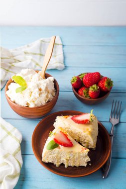 süt ve suyu beyaz mavi zemin üzerine çilek cheesecake dilim. Ev yapımı ve lezzetli. Aile diyet kahvaltı.