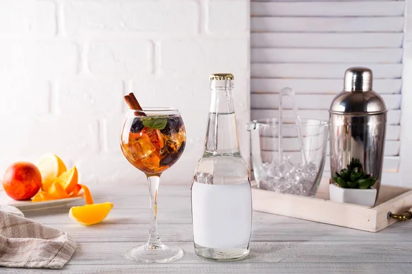 Buzlu çay, viski, çilek ve buz bir şişe ile bir bardak tonik ve bir yerde şişesini Beyaz ahşap zemin üzerinde metin altında kokteyl
