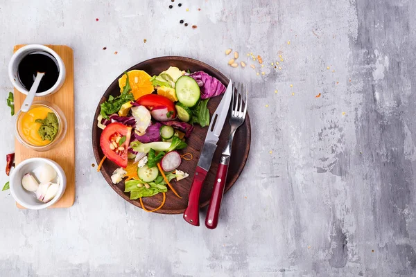 健康的沙拉盘子里有西红柿 沙拉和黄瓜 萝卜与源敷料在石材背景平躺 食物和健康 清洁饮食 — 图库照片