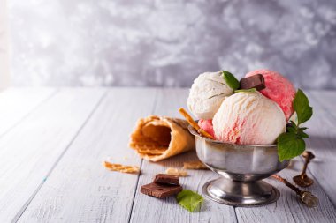 Gofret payet ve buz çilek ahşap arka plan üzerine bir kase dondurulmuş tatlı lezzetli vanilya ve çilek aromalı