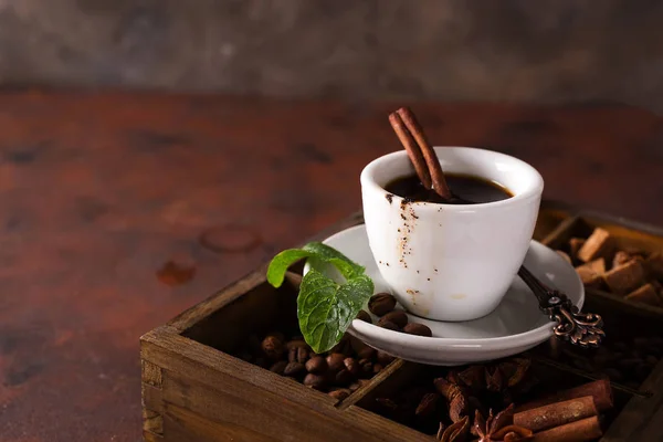 巧克力松饼与一杯咖啡在一个木盒上的咖啡和香料的石头背景 — 图库照片