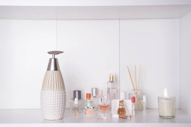 Parfüm şişeleri ışık arka plan üzerinde aroma sopa ile. Parfümeri, kozmetik, parfüm koleksiyonu. Metin için özgür yer. Aromaterapi Spa ayarla