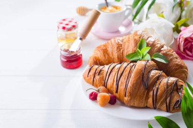 taze pişmiş kruvasanlar meyveleri ile masaya servis ile plaka