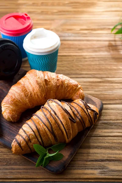 ahşap masa üzerinde kahve fincanı ile taze pişmiş kruvasanlar 