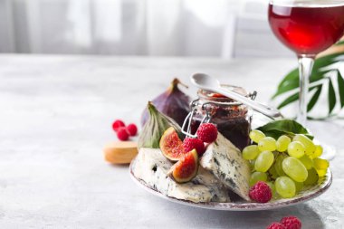 incelik mavi peynir, meyve ve reçel kavanoz cam beyaz taş zemin üzerine kırmızı şarap ile alanı Kopyala