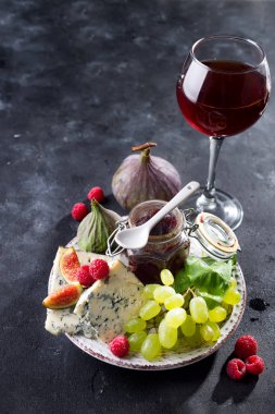 incelik mavi peynir, meyve ve reçel kavanoz cam siyah arduvaz taş zemin üzerine kırmızı şarap ile alanı Kopyala