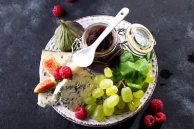 incelik mavi peynir, meyve ve reçel kavanoz palmiye yaprağı karanlık kayrak taş zemin üzerine alan kopyalama