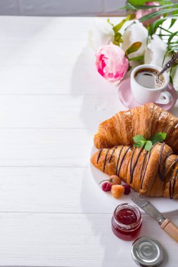 taze pişmiş kruvasan reçel ile dekore edilmiş kahvaltı ve çikolata, çiçek ile bir mutfak ahşap tablo alanı Kopyala
