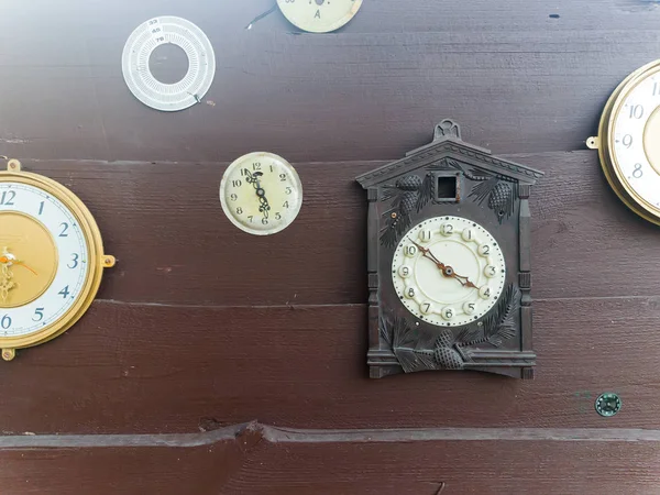 Συλλογή vintage ρολόι που κρέμεται από ένα παλιό ξύλινο τείχος σχετικά με τους εξωτερικούς χώρους με ηλιοφάνεια — Φωτογραφία Αρχείου