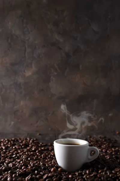 Kopp hett kaffe på bakgrunden av kaffe korn på en trä bakgrund, kopia utrymme — Stockfoto