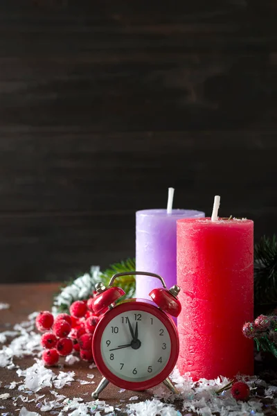 Candles, old clock and Christmas decoration on dark wooden background, copy space