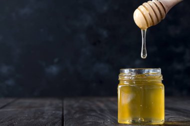 Kepçe eski ahşap masa üzerinde kavanoza damlama tatlım