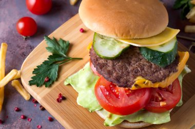 Lezzetli ev yapımı Hamburger sığır eti, domates, peynir, salatalık, marul ile yemek ızgara. Görünümü en çok, yakın çekim