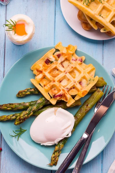 녹색 구운된 와플 삶은 아스파라거스 데친 계란, 소금, 향신료 파란색 접시에 평평 하다 건강 한 아침으로. — 스톡 사진