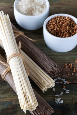 Erişte soba ve sommel, buğday ve pirinç bir eski ahşap arka plan üzerinde kaseler