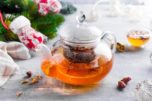 Glass teapot with flowers tied tea, Hot tea in glass teapot and honey with metal honey stick on stone background, Christmas concept — Stock Photo, Image