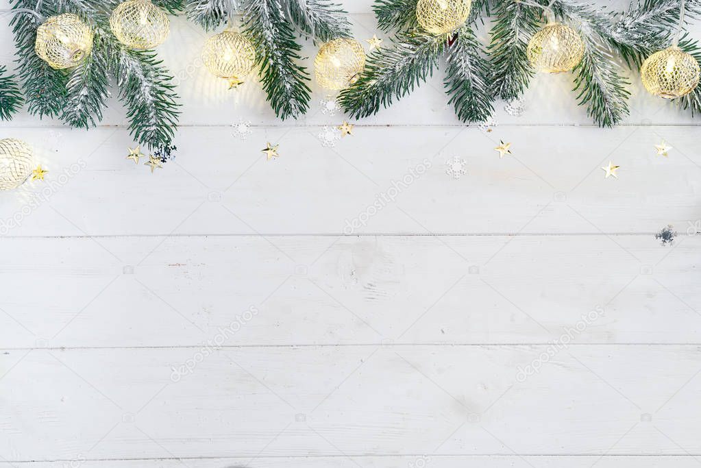 Christmas banner empty template made with fir branches and garland on white wooden tabletop
