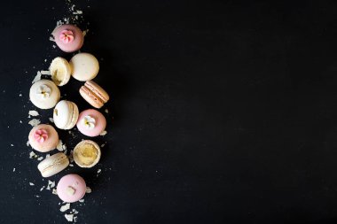 Renkli macarons siyah taş zemin üzerine. Kopya alanı ile üstten görünüm.