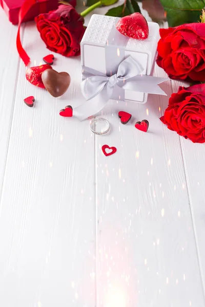 Sevgililer çikolata-aşk tatlı kalp şeklinde çikolata şekerleme hediye kutu kırmızı gül beyaz bir ahşap zemin üzerine ile — Stok fotoğraf