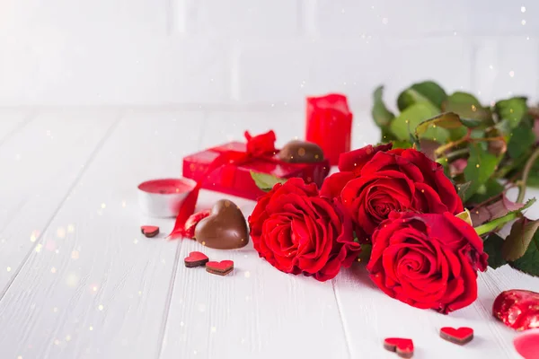 Bonbons chocolats en forme de coeur doux Valentines Chocolate-Love avec boîte cadeau sur un fond en bois blanc avec des roses rouges — Photo