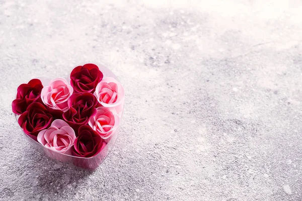 Rosa brillante e rose rosse fatte di trucioli di sapone, in una scatola a forma di cuore. Valentines spa romantica — Foto Stock
